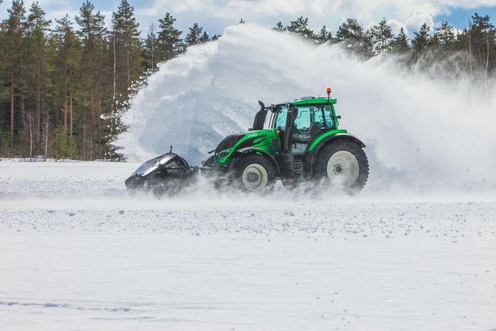 Traktor odśnieżający pole z dmuchawą śniegu